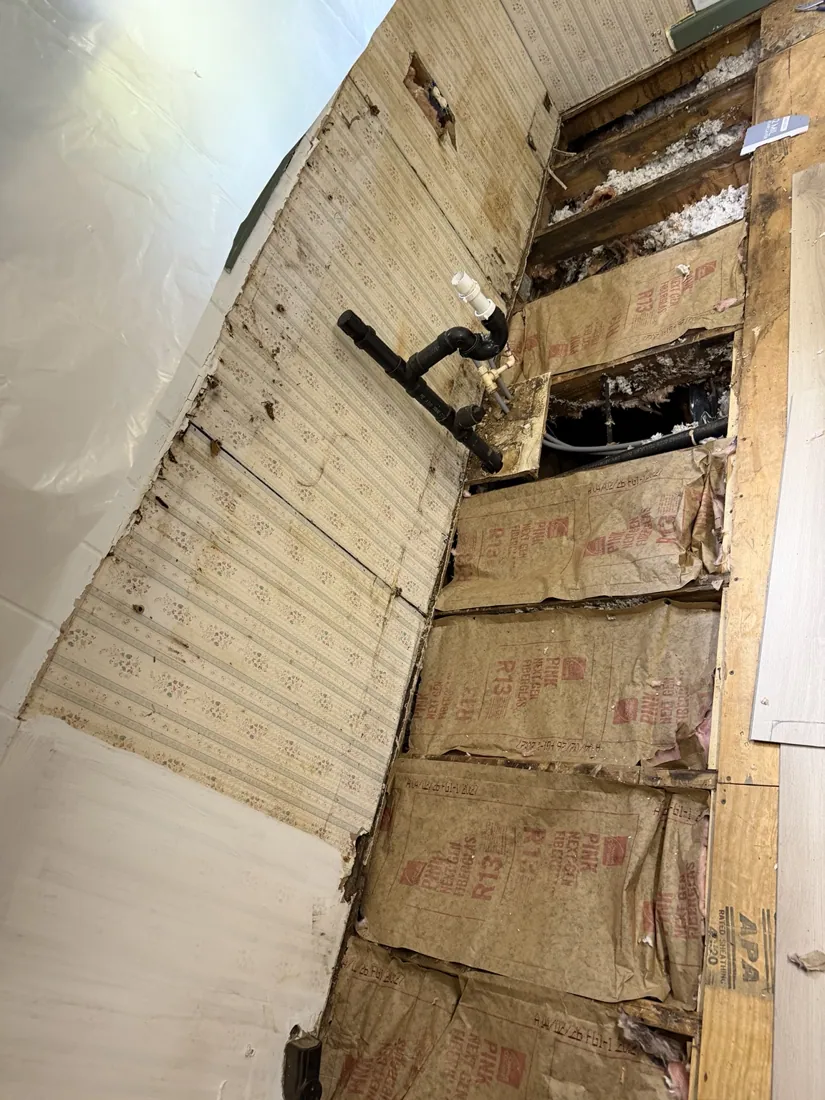 Kitchen floor opened during demolition showing joists and plumbing