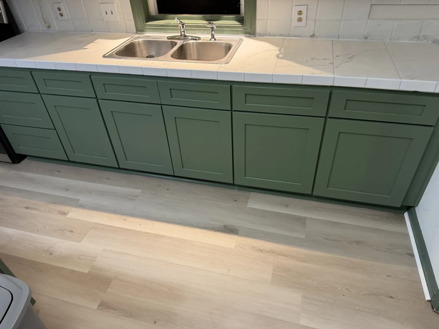 Refreshed green kitchen cabinets and updated countertop with new flooring