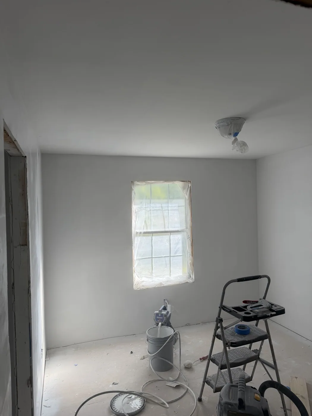 White room with freshly finished walls and ceiling during painting work